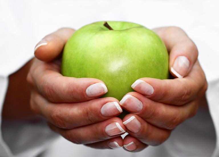 Zielone jabłko w dłoniach